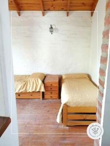 twee bedden in een kleine kamer met houten vloeren bij Jarillas del Mar in Las Grutas