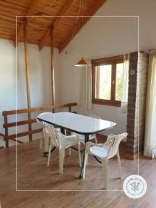 uma mesa de jantar e cadeiras num quarto com uma mesa em Jarillas del Mar em Las Grutas