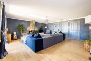 a bedroom with a blue couch in a room at Chic Family Barn, edge of Frome + country views in Frome