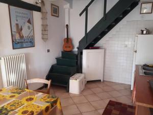 a kitchen with a table and a staircase with a guitar at Ecogarden camping with rooms in Zelarino