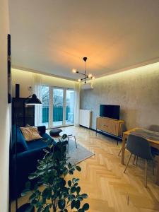 a living room with a blue couch and a table at Drewnowska 77 Prime Apartment in Łódź