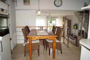 a dining room table with chairs and a clock on the wall at Ferienwohnung Scheid in Scheid