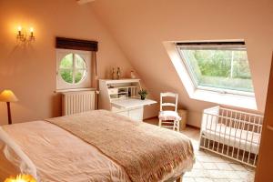 1 dormitorio con cama, ventana y cuna en Marie campagne en Mont-Saint-Guibert