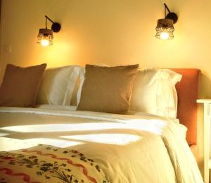 um quarto com uma cama branca e 2 luzes em Domaine de La Barde apartments in the old walnut mill and forge em Le Bugue