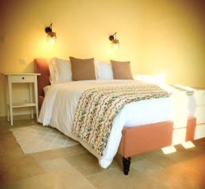 1 dormitorio con 1 cama grande con sábanas y almohadas blancas en Domaine de La Barde apartments in the old walnut mill and forge, en Le Bugue