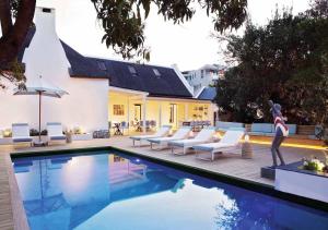 a swimming pool with lounge chairs and a swimming pool at The Old Rectory in Plettenberg Bay