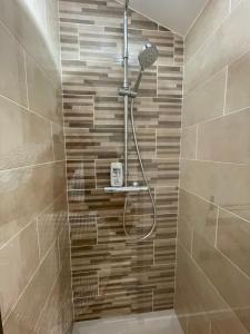 a shower with a shower head in a bathroom at Le Gîte du Prieuré in Bellefond