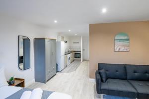 uma sala de estar com um sofá azul e uma cozinha em Paradise Suite em Portsmouth