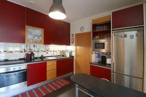 ヴィラモウラにあるHiva T3 By FHRのキッチン(赤いキャビネット、ステンレス製の冷蔵庫付)