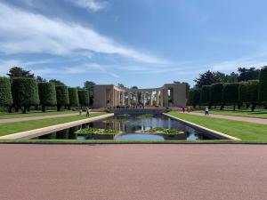 a building with a pond in front of a garden at Willow Farm Gite in Saint-Martin-de-Chaulieu