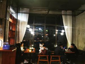 a group of people sitting at tables in a restaurant at 0517 Boutique Hotel in Huangshan City