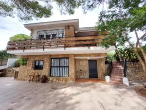 a house with a balcony on top of it at Chalet con piscina y barbacoa, Valencia in Torrent