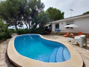 a swimming pool in front of a house at Chalet con piscina y barbacoa, Valencia in Torrent