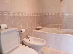 łazienka z toaletą i wanną w obiekcie Citymar Vilamoura T2 com piscina w mieście Vilamoura