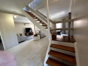 - un escalier dans une pièce avec un salon dans l'établissement Beachside Modern Cedar Home, à Emu Park