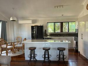 een keuken met een aanrecht en een tafel en stoelen bij Beachside Modern Cedar Home in Emu Park