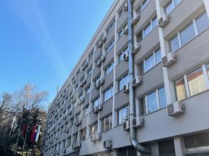 um edifício de apartamentos com canos na lateral em Hotel Rex em Belgrado