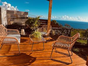 4 sillas y una mesa en una terraza de madera en La Villa Choka, en Trois Bassins