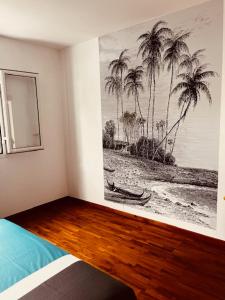 une chambre avec une photo de palmiers sur le mur dans l'établissement La Villa Choka, à Trois Bassins