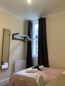 a bedroom with a bed with a mirror and a window at Lovely Private Rooms in Camden, Central London in London