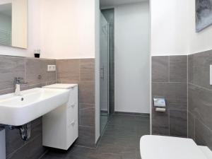 een badkamer met een wastafel, een toilet en een douche bij Ohlerich Speicher App_ 33 in Wismar