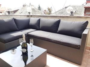 a couch on a balcony with a bottle of wine on a table at Open Space Spa Apartment Monza National Arena in Colonişti