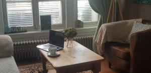 a living room with a table with a laptop on it at Maison de Berry Bed & Breakfast in Villedieu-les-Poêles