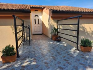 a house with a white door and potted plants at Vila Marija in Rab