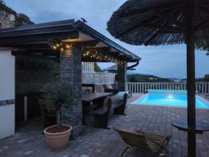 a patio with an umbrella and a swimming pool at Vila Marija in Rab