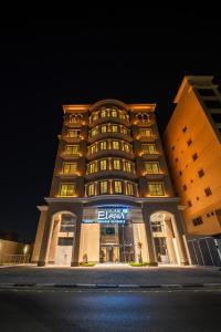 um grande edifício com uma placa à noite em فنـــــــــدق ايليفــــــــــــار Elevar Hotel em Al Khobar