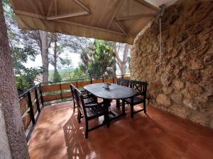una mesa y sillas en un porche con una pared de piedra en Chalet con piscina y barbacoa, Valencia en Torrent