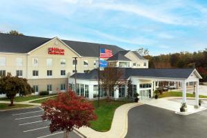 ein Hotel mit amerikanischer Flagge auf einem Parkplatz in der Unterkunft Hilton Garden Inn Solomons in Dowell