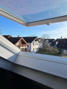 a window with a view of a house at Ferienwohnung Alex Mayer in Langenargen