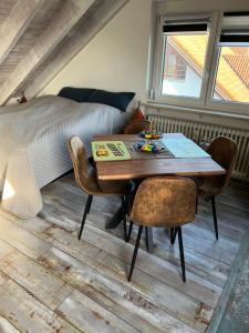 um quarto com uma secretária, uma cama, uma mesa e cadeiras em Ferienwohnung Alex Mayer em Langenargen