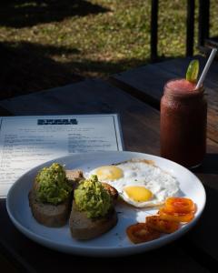 a plate of eggs and toast and a drink at Swell Shacks in Matara