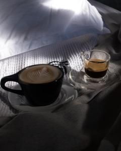 a cup of coffee and a glass of tea on a bed at Swell Shacks in Matara