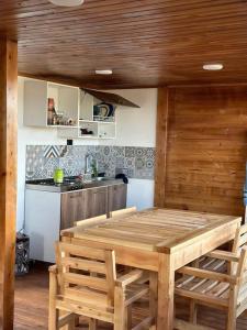 a kitchen with a wooden table and some chairs at Villa San Jerónimo in Tota