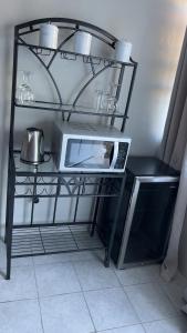 a black shelf with a microwave and a tea kettle at Dream Stay Studio 2 in Vieux Fort