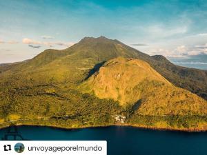 an island in a body of water with a mountain at Bintana Sa Paraiso in Mambajao