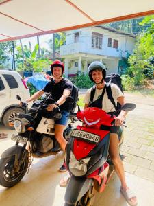 two people are sitting on a motor cycle at Summer Ridge - Homestay in Ratnapura
