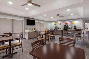 a dining room with tables and chairs and a kitchen at Quality Inn near Casinos and Convention Center in Bossier City