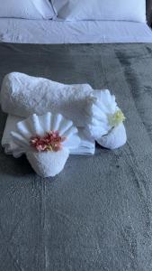 two towels and a flower on a bed at Dream Stay Studio 2 in Vieux Fort