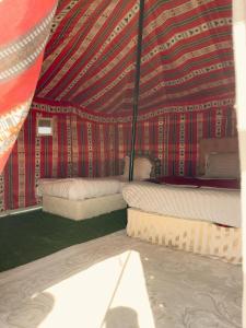 a room with two beds in a tent at Hamood desert local camp in Al Wāşil