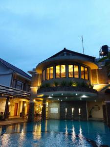 a large building with a swimming pool in front of it at Hotel Sriti Magelang in Magelang