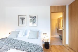 a white bedroom with a bed and a table at Isard Homes by Select Rentals in El Tarter