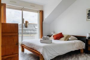 1 dormitorio con cama y ventana grande en Epicea- Spacieux 3 chambres avec parking., en Nantes