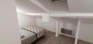 Kleines weißes Zimmer mit einem Bett und einem TV in der Unterkunft Appartement 2 chambres in Champdeniers