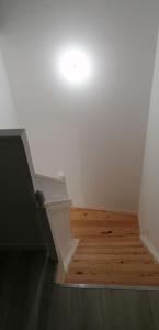 eine Treppe mit einer weißen Wand und Holzböden in der Unterkunft Appartement 2 chambres in Champdeniers