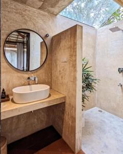 uma casa de banho com um lavatório e um espelho em Swell Shacks em Matara