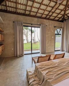 a bedroom with a large bed and a large window at Swell Shacks in Matara